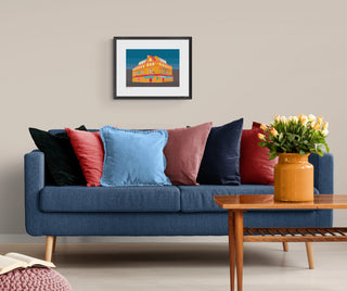 Art print of Bedford Pub hanging above a denim blue sofa.