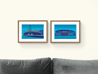 Two blue framed prints with illustrations of Cardiff Millennium Stadium and Emirates Arsenal football stadium.