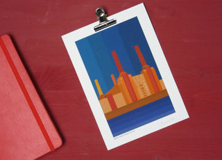 Blue, red and orange print of Battersea Power station. Inspired by Farrow & Ball's red incarnadine paint, it sits on a shelf of that colour.
