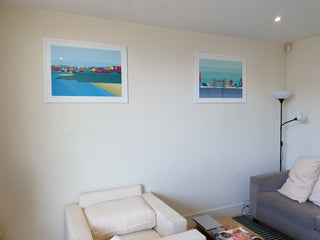 Two South Island Art prints framed and hanging in a living room.