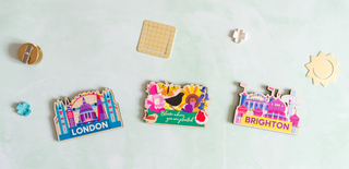 Three colourful magnets with 'London', 'Brighton', and a floral design on a light mint green background.