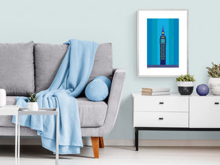 Blue Big Ben art print on a pale blue living room beside a grey sofa and white modern cabinet.