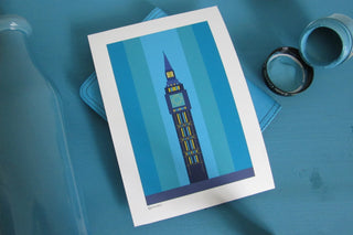 Blue Big Ben print on a painted blue shelf with a vase of the same colour and pot of Little Greene paint.