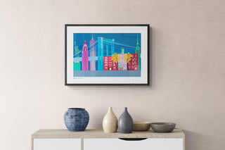 Illustrated New York Landmarks print in blue, green and pink hangs on a pale pink wall above a wooden cabinet