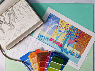 A flatlay of sketches, paint swatches and a printed proof of a New Forest landscape