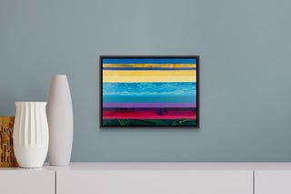 Original painting of colourful stripes in a dark floater frame, hanging on a blue-grey wall.
