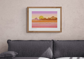 Framed print of Sunset Over The Mountains by South Island Art on a dusky pink wall.